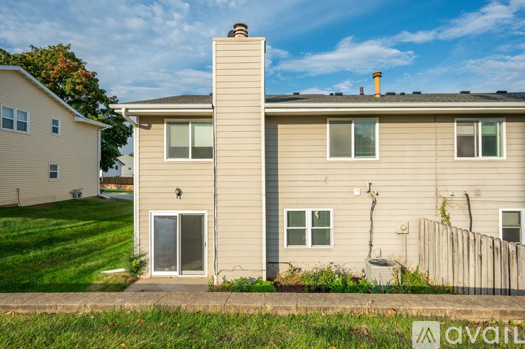 A beige house with a grey roof and a chimney.