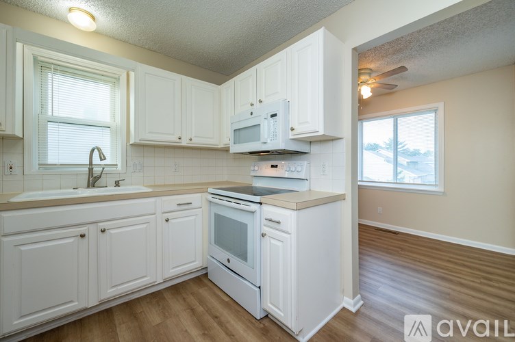 A kitchen with white cabinets and appliances.