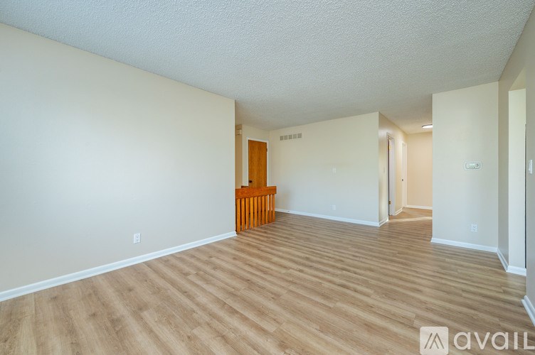A room with wooden flooring and a wooden chair in it.