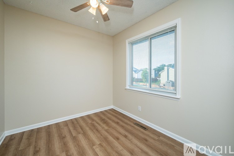 A room with a ceiling fan and a window.