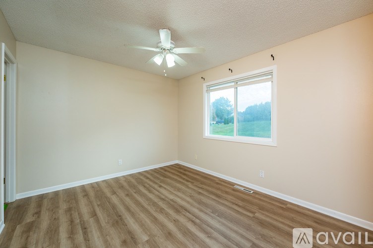 A room with a ceiling fan and a window.