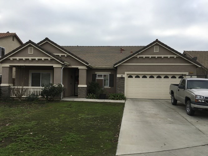 A house with a grey truck parked in front.