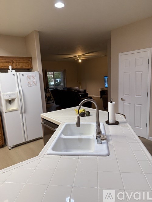 A kitchen with a white fridge and sink.
