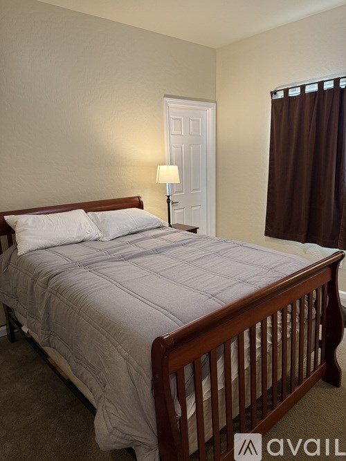 A bed with a white comforter and a wooden headboard.