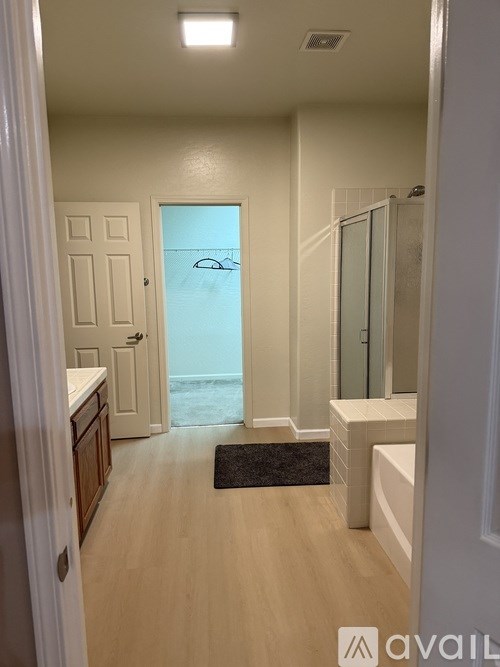 A bathroom with a walk-in shower and a door leading to a balcony.