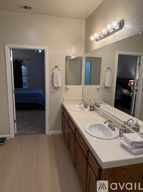 A bathroom with a white countertop and a mirror above it.