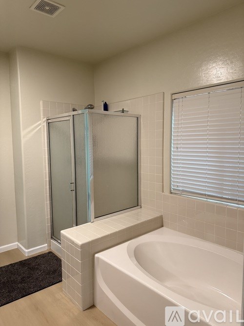 A bathroom with a white tub and a glass shower door.