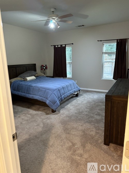 A bedroom with a bed, dresser, and window.