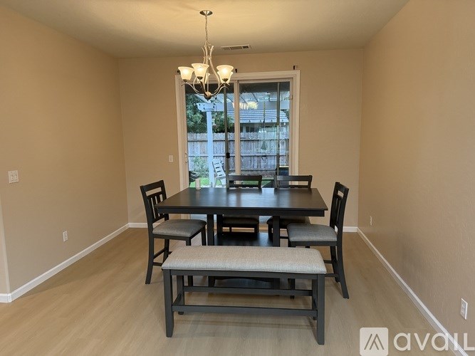 A dining room with a table and chairs.