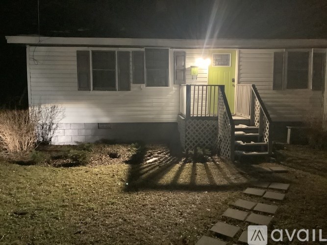 A house with a green door and a lit up porch.