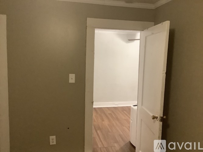 A room with a white door and a wall socket.