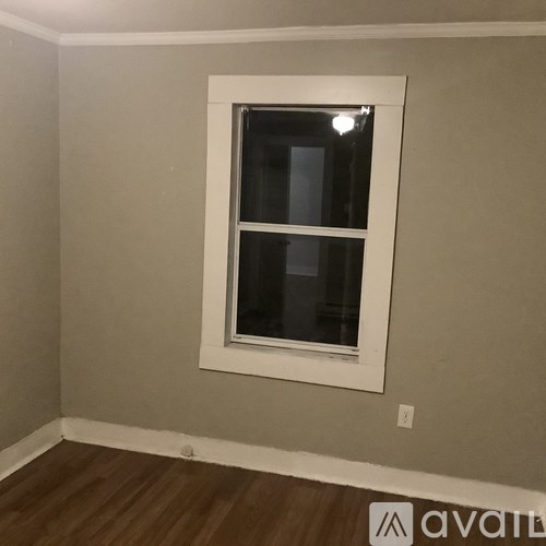 A window in a room with a wooden floor.