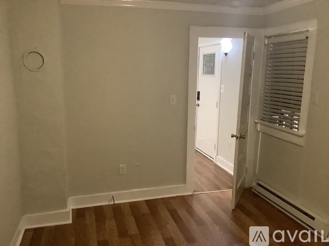 A room with a white door and a window with blinds.