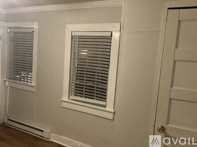 A white door with a window with blinds on the side of a room.