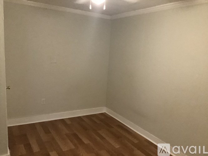 A room with wooden flooring and white walls.