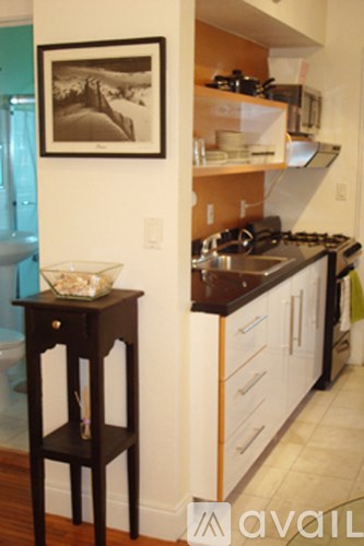 A kitchen with a black and white picture on the wall.