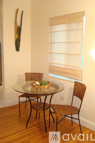 A glass table with four chairs around it.