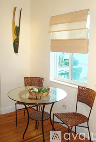 A table with chairs and a window with blinds.