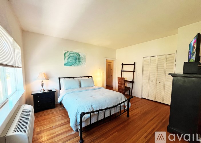 A bedroom with a bed, dresser, and a painting on the wall.