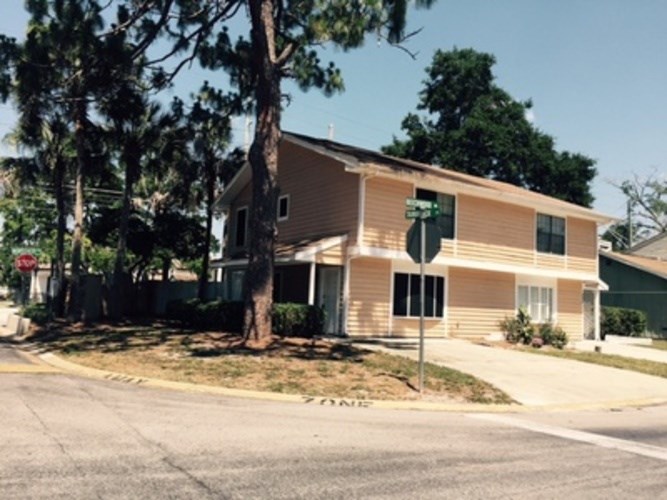 A house with a green sign in front of it.