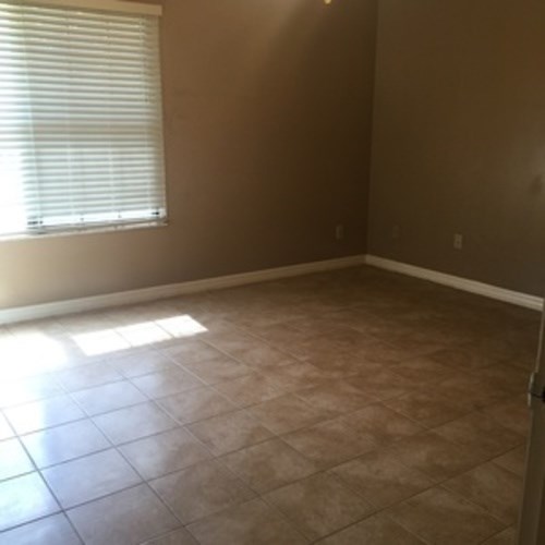 A room with a window and tile flooring.