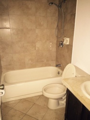 A white toilet is next to a bathtub in a bathroom.