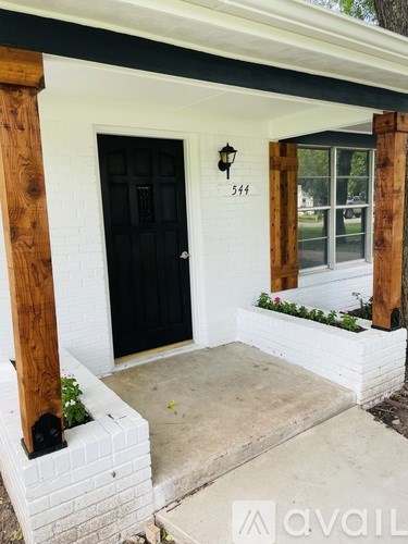 A black door is on the left side of a white house.