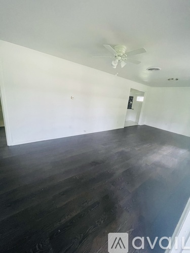A room with wooden floors and a ceiling fan.