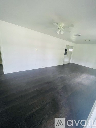 A room with wooden floors and a ceiling fan.