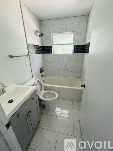 A bathroom with a toilet, sink, and bathtub.