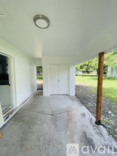 A white door is in the middle of a concrete floor.