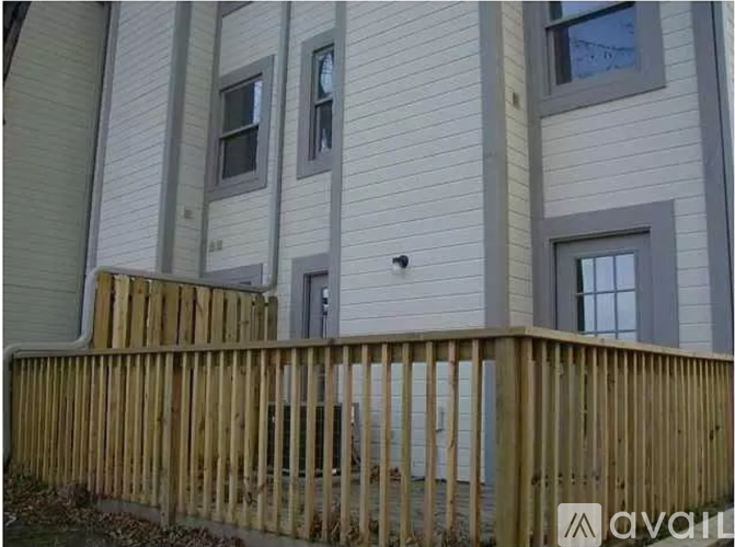 A wooden fence in front of a building with windows.