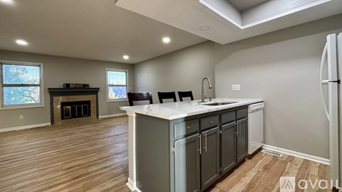 A kitchen with wooden floors and a white countertop.