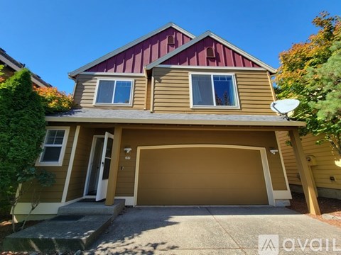 A house with a brown and beige exterior and a red roof.