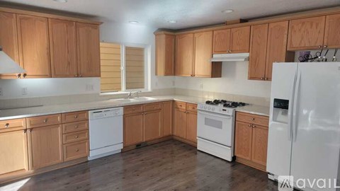 A kitchen with wooden cabinets and white appliances.
