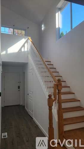 A staircase with a wooden banister and a sign that says "available" on the bottom left.