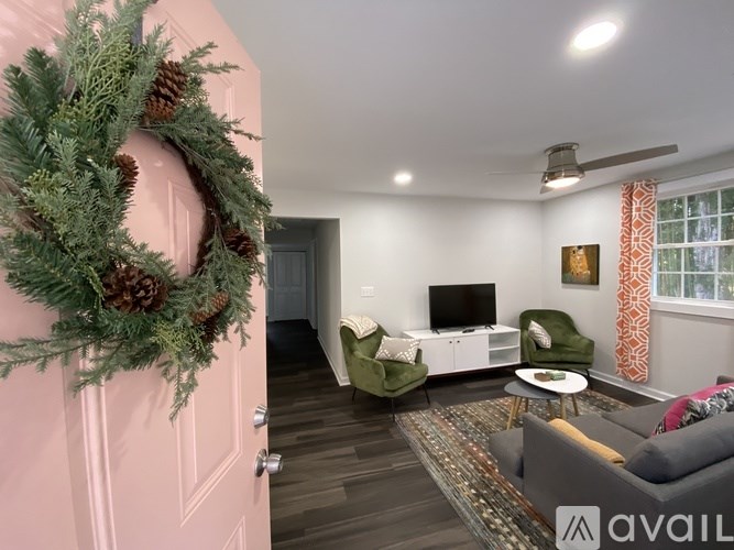A living room with a pink door and a wreath on it.
