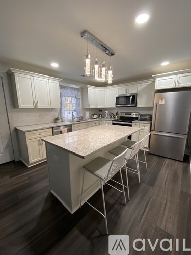 A kitchen with a table and chairs in front of a refrigerator.