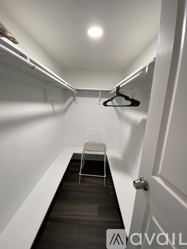 A white chair is placed in a hallway with a black floor.