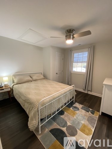 A bedroom with a bed, nightstand, and window.