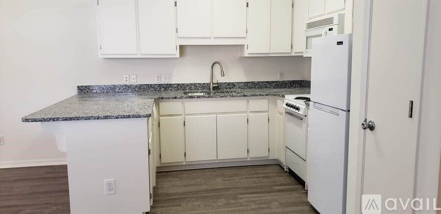 A kitchen with white cabinets and a granite countertop.