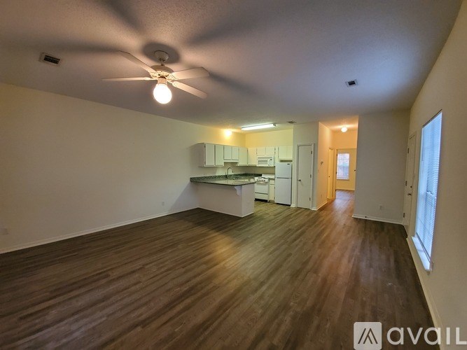A room with wooden floors and a ceiling fan.