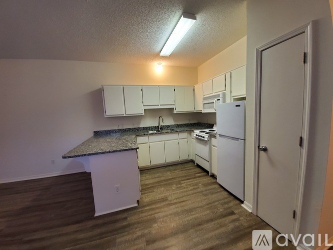 A kitchen with white appliances and cabinets.