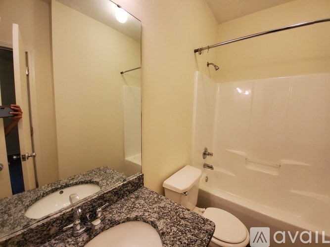 A bathroom with a granite countertop and a walk-in shower.