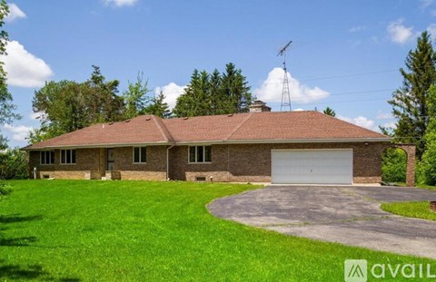 A house with a garage and a driveway in front of it.