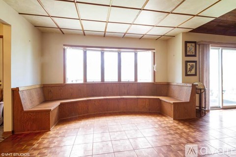 A room with a bench and windows.