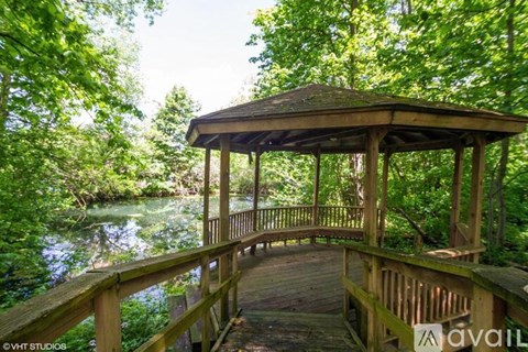 A gazebo sits on a wooden deck overlooking a body of water.