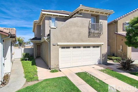 A house with a white garage door and a balcony with a railing.