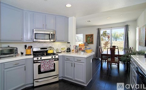 A kitchen with a stove, oven, microwave, and cabinets.