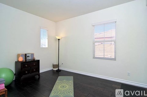 A room with a large window, a dresser, and a ball.